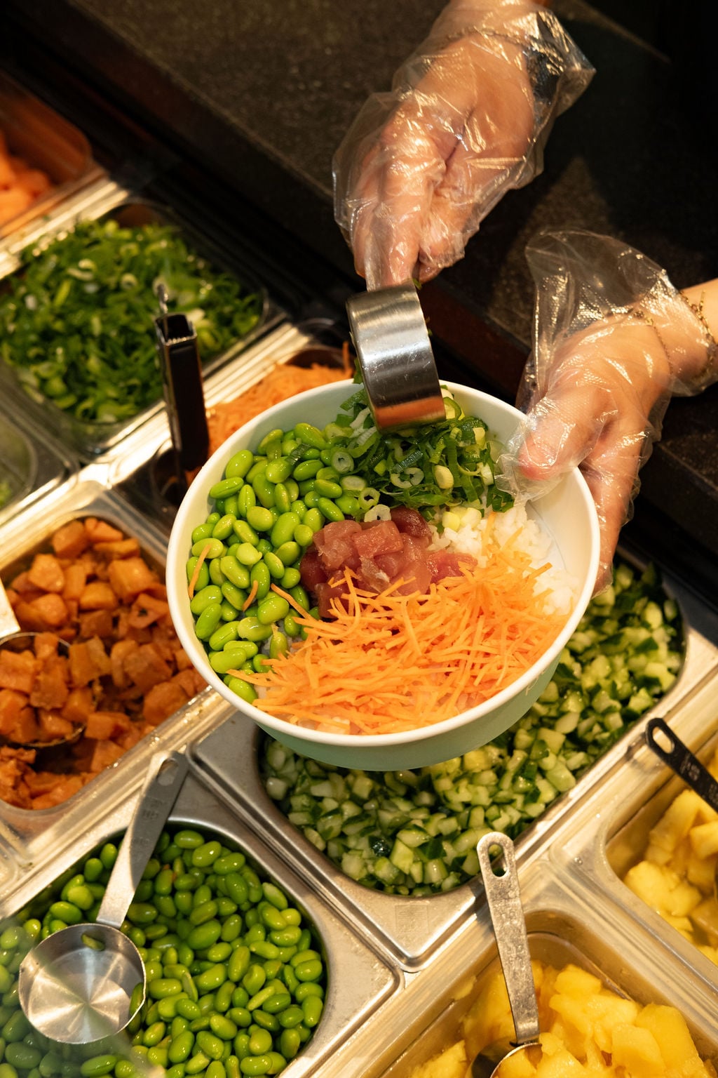 Poké Perfect team member assembling a bowl